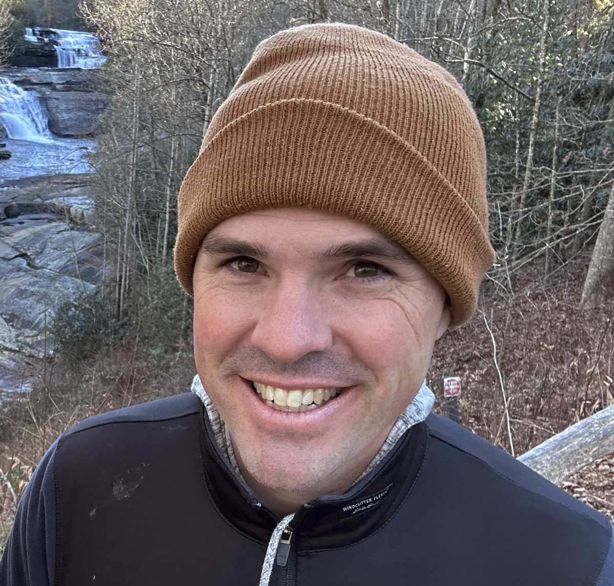 Matthew Dickerson smiling outdoors in front of a waterfall