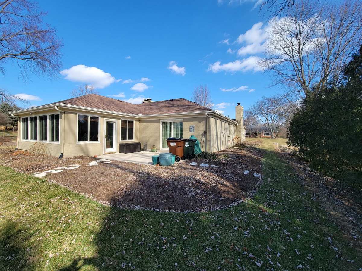 Backyard before: bare bed and worn lawn behind the house