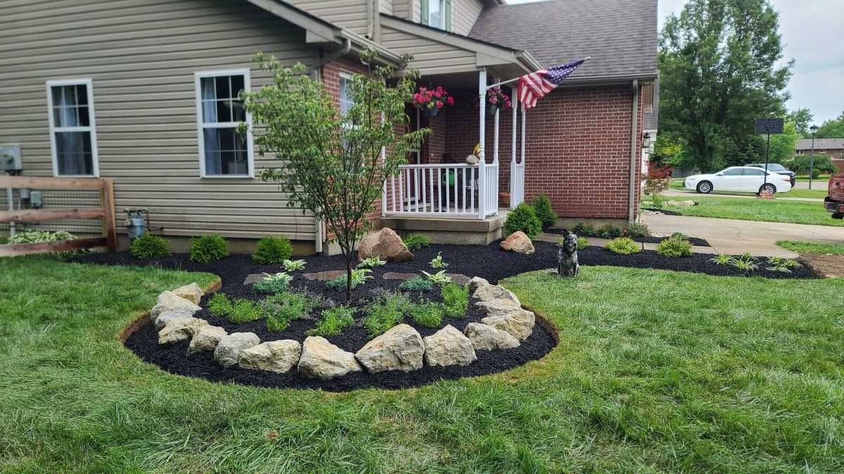 Front yard island bed edged with natural stone