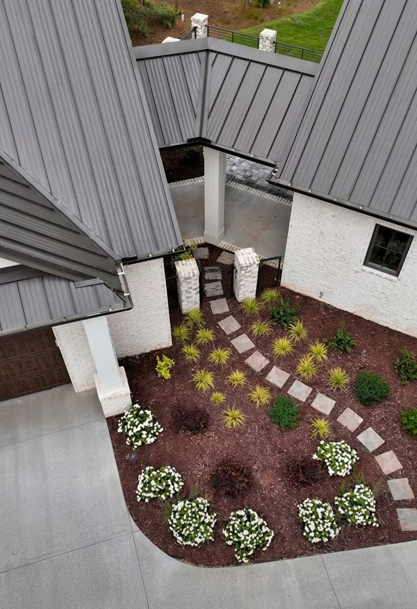 Aerial view of a courtyard garden with a stepping-stone path, ornamental grasses and white flowering shrubs