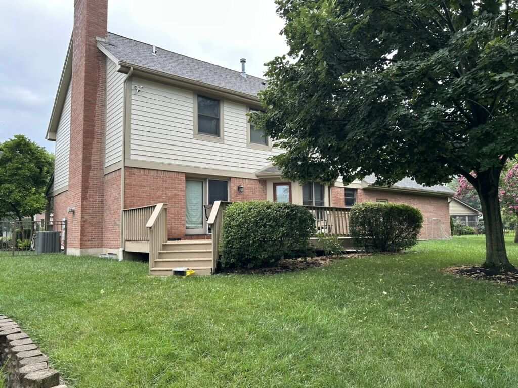 Rear of house before: wooden deck and overgrown shrubs